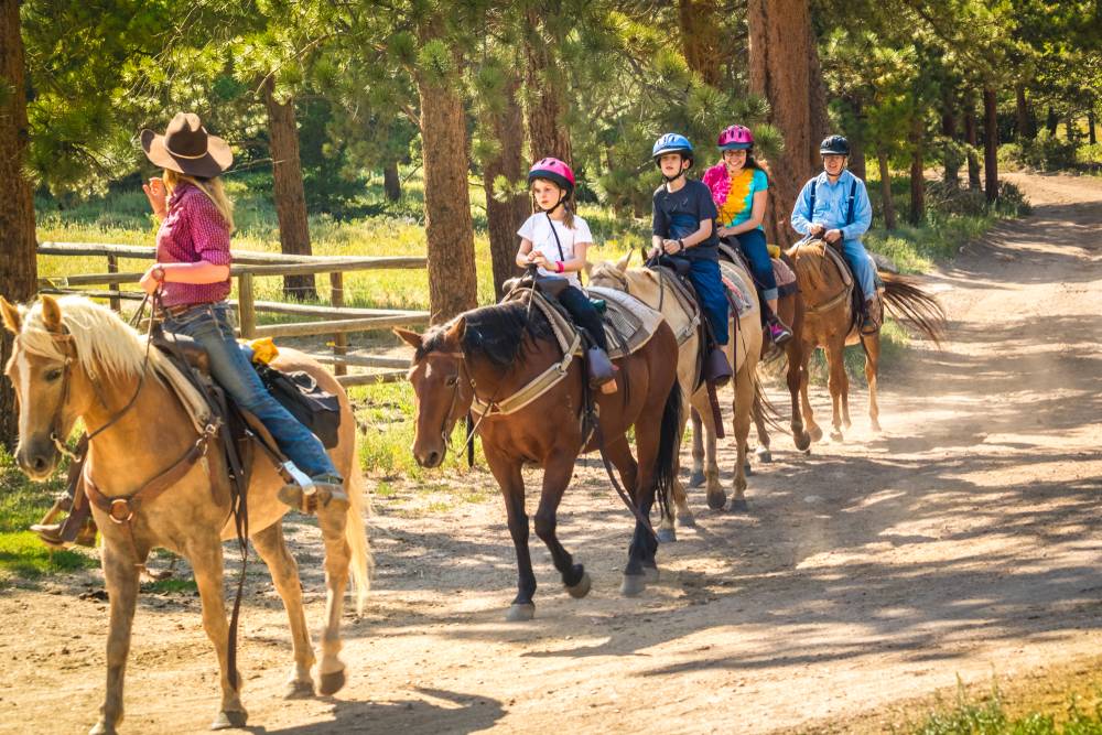 kids riding horses with adults