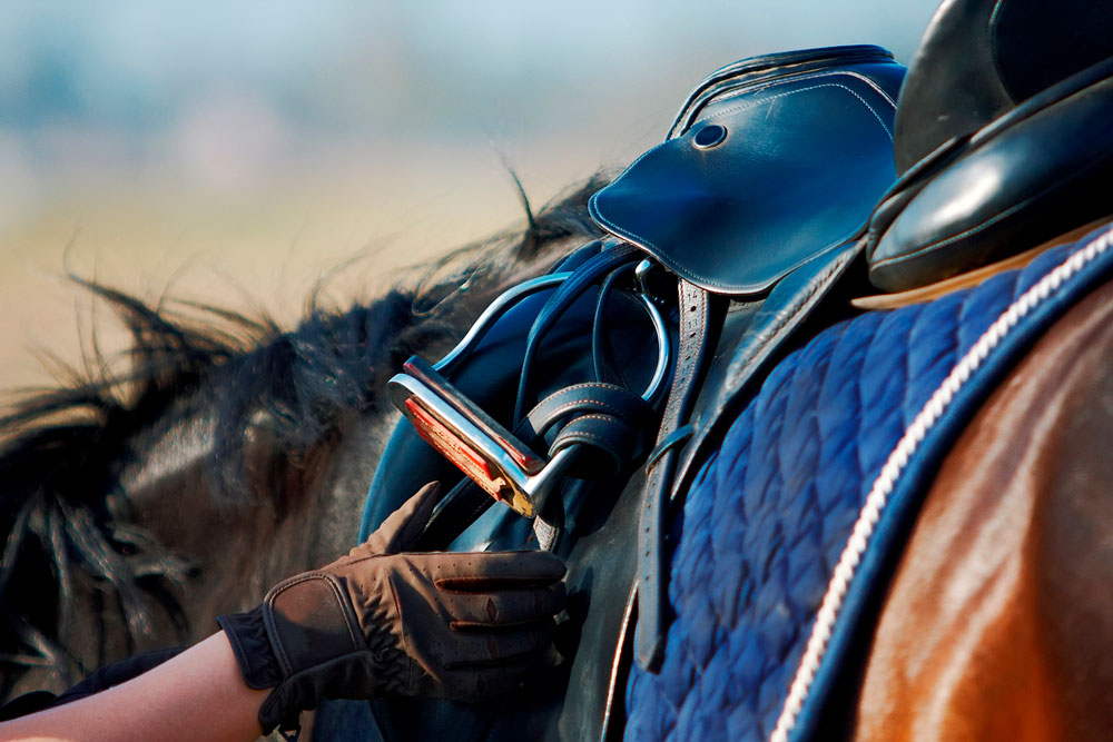 rider checks saddle stirrups