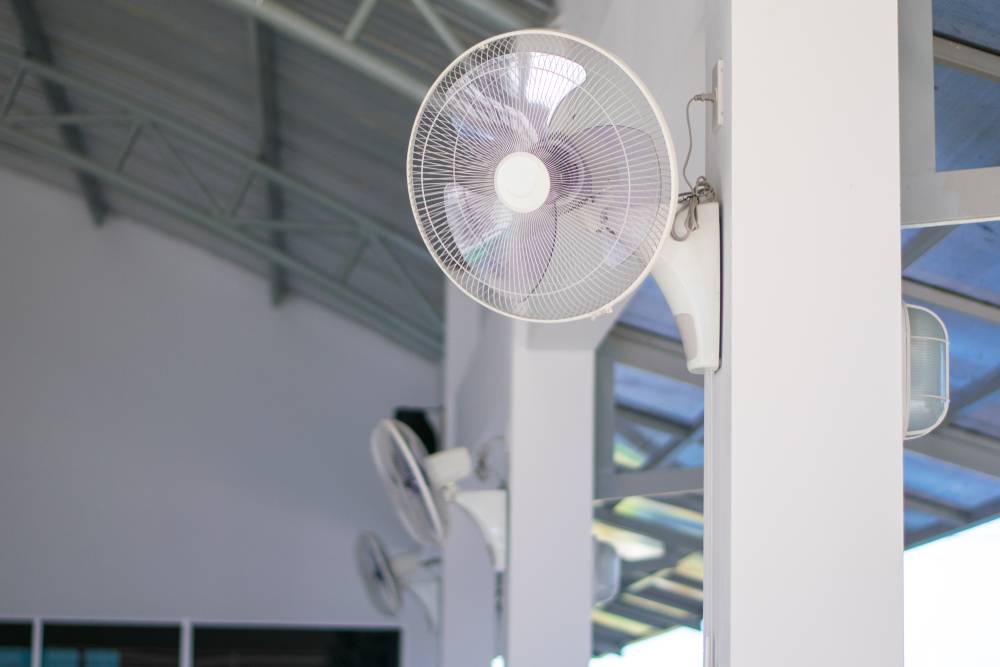 white electric fans installed on the walls